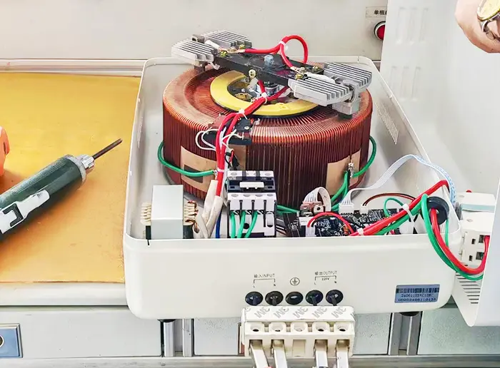 Electrician wiring live, neutral, earth to a single‑phase voltage stabilizer